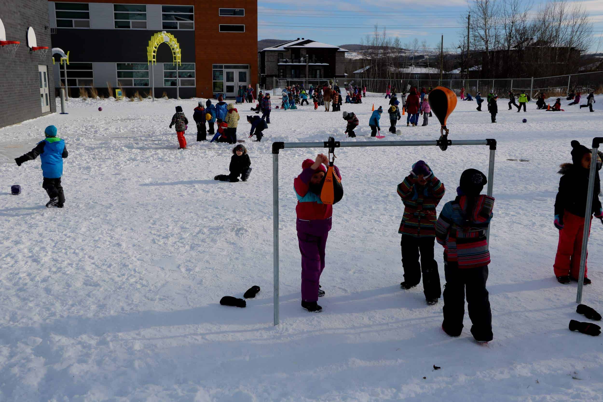 plusieurs enfants qui s'amusent en hiver dans une cour d'école